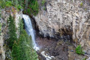 Large rocky cliffs surrounding the majestic Lost Creek Falls along Lost Creek. Yellowstone National Park, Wyoming