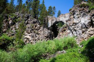The Natural Bridge rising above the surrounding landscape at the end of the Natural Bridge Trail. Yellowstone National Park, Wyoming